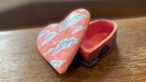 Pink heart shaped ceramic box with clouds on top. Example of something that can be made at Valentine's Clay Date.